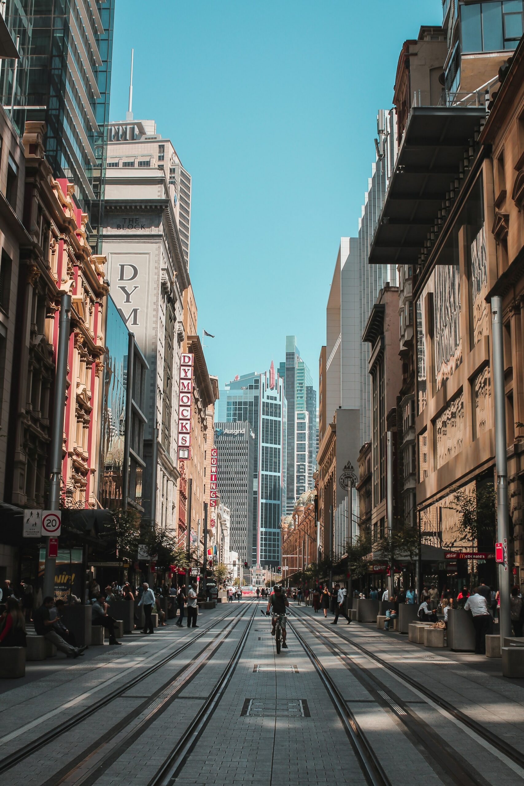 A cyclist riding down tram tracks on a pedestrian street in Sydney