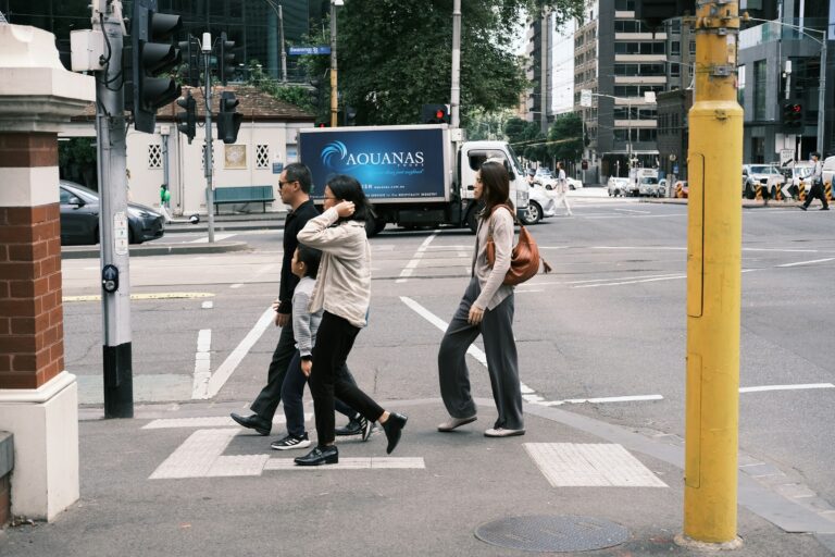 Commuters crossing a city street at a pedestrian crossing in Australia